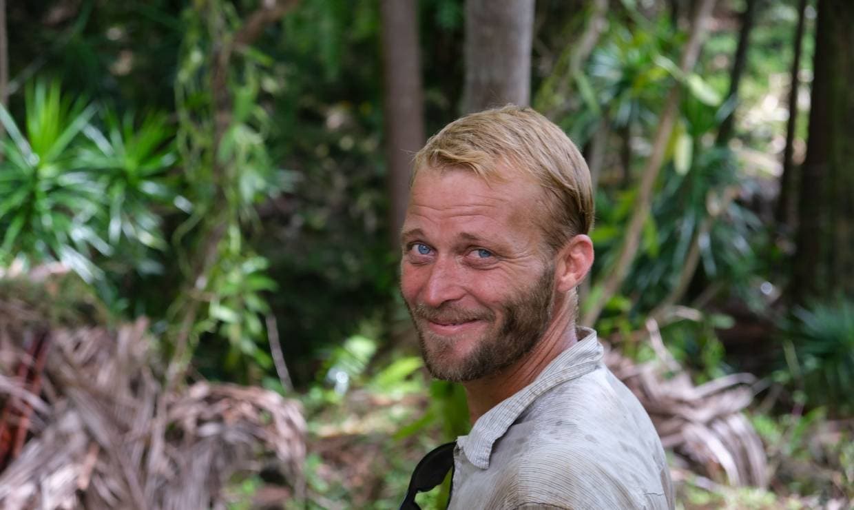 Portrait de Quentin Donnay souriant dans la foret de Sainte-Rose